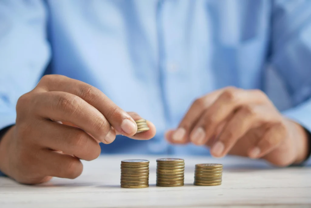 A person's hands stacking coins